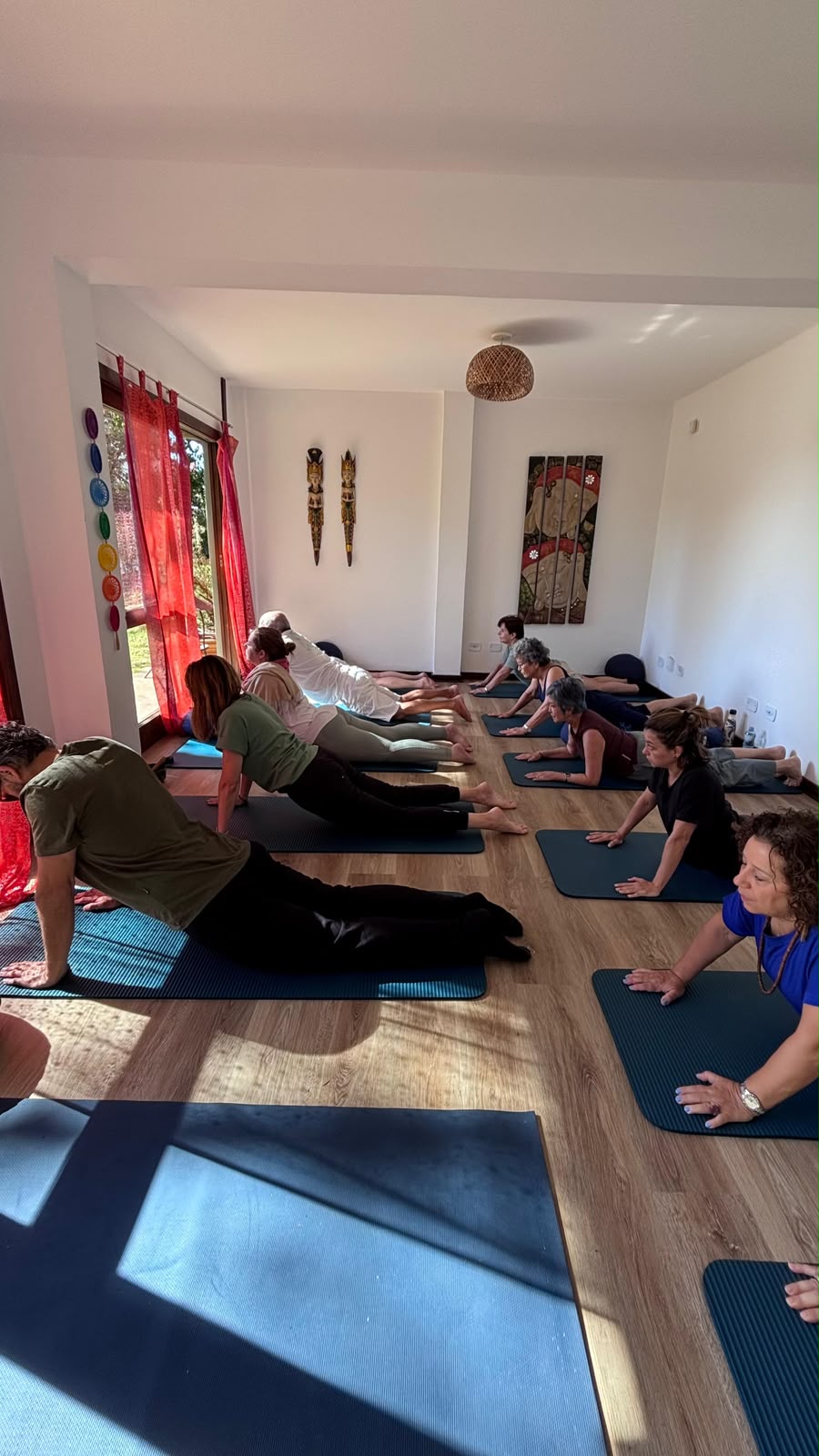 Grupo praticando yoga em sala iluminada