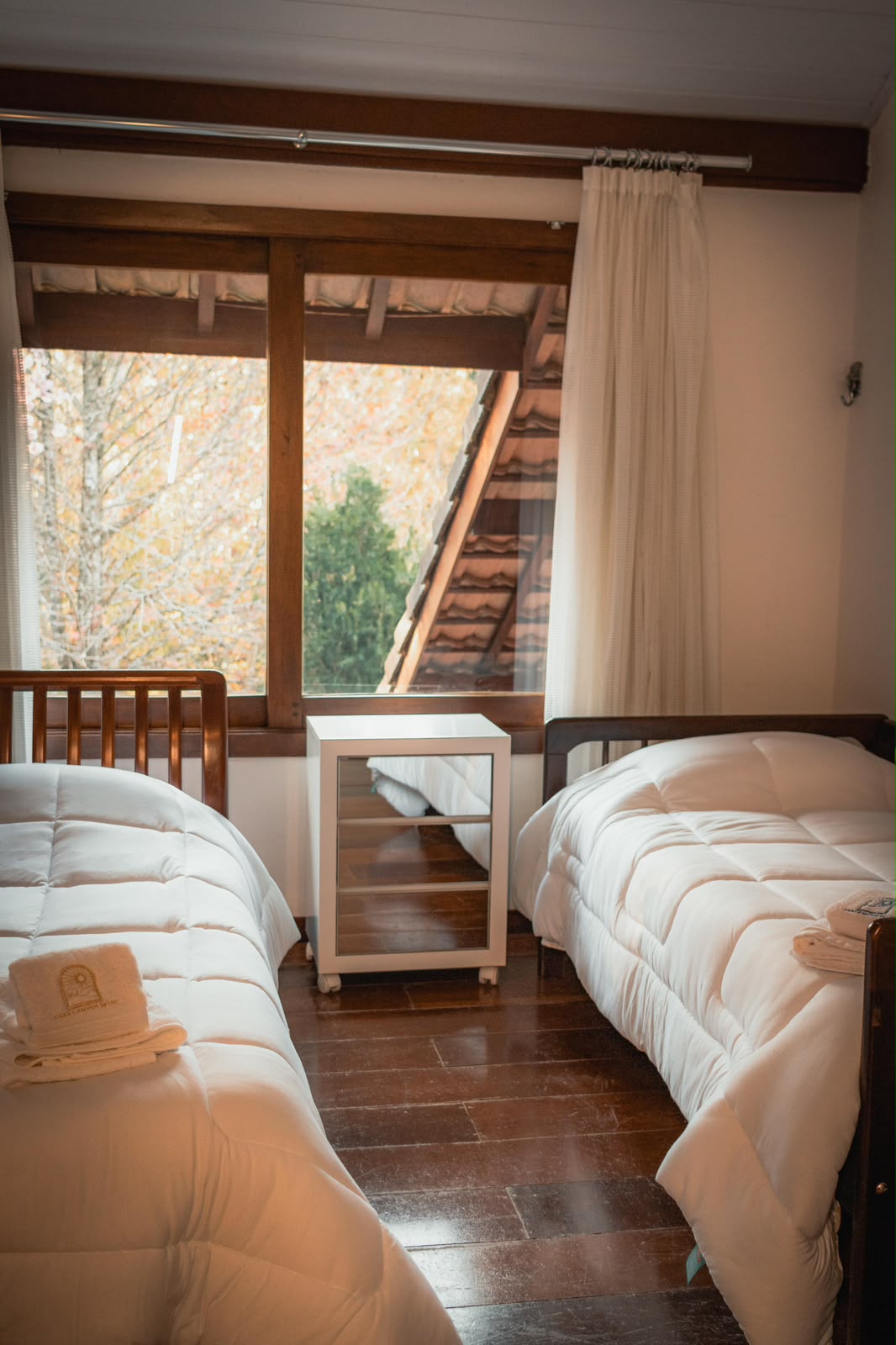 Quarto com duas camas e janela para a natureza