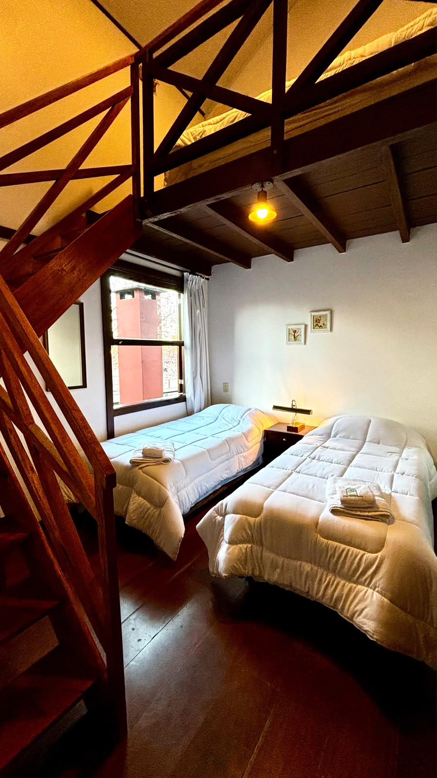 Quarto com mezanino, camas preparadas e luz quente